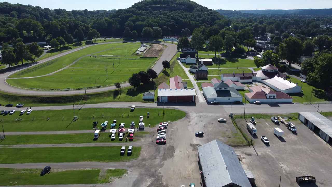 Aerial view of the Fairfield County Fairgrounds with barns, a racetrack, and parked cars