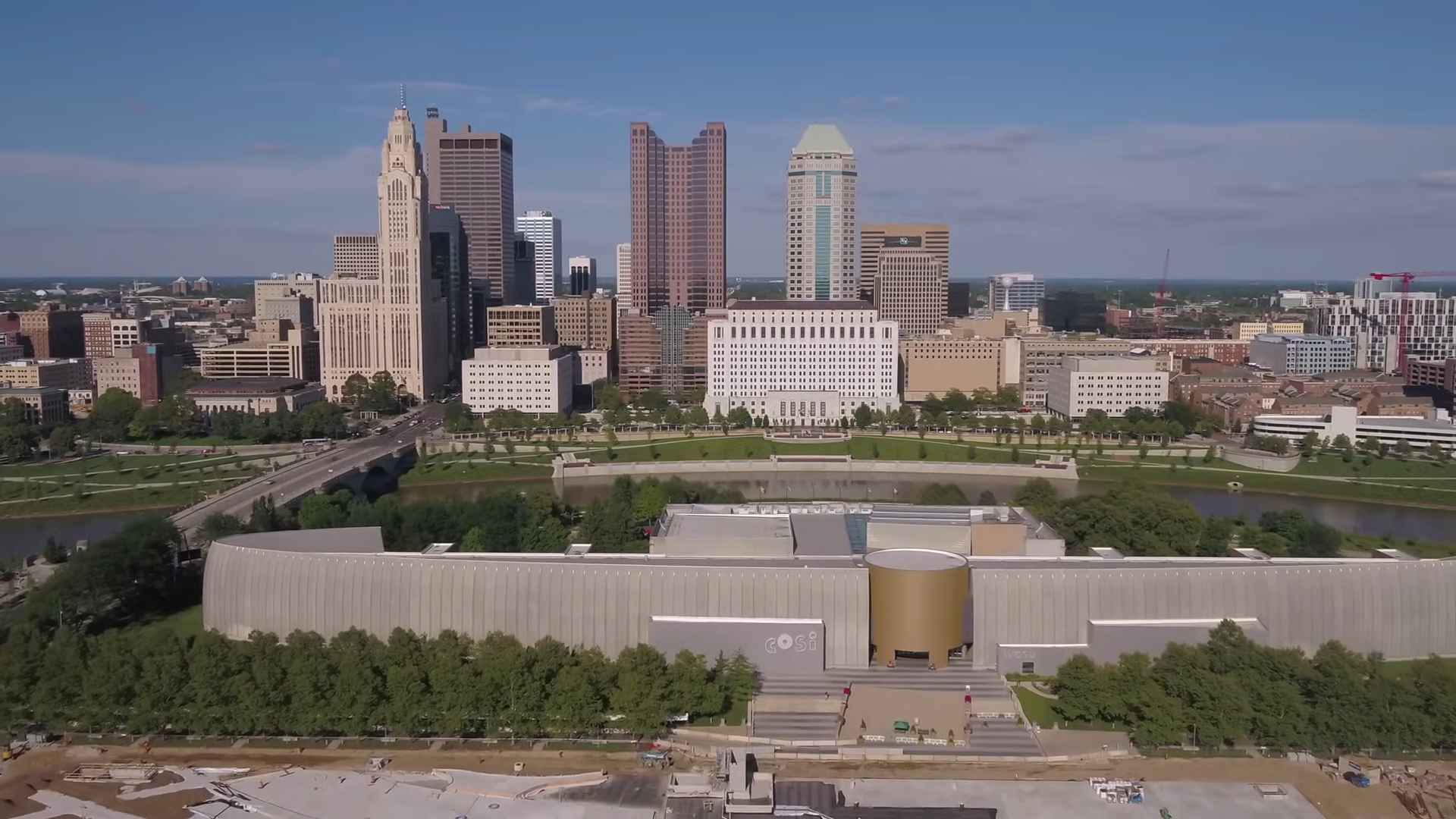 Aerial view of downtown Columbus, Ohio, featuring skyscrapers, the Scioto River, and the COSI science center
