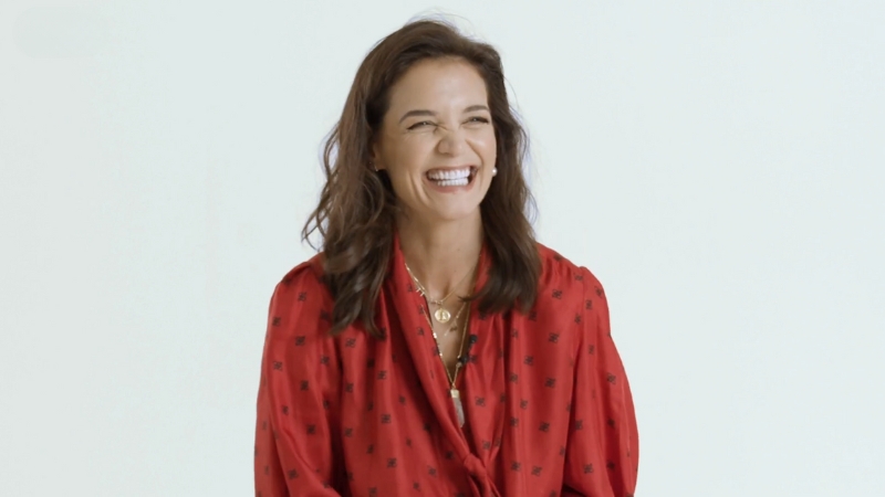 Katie Holmes smiles in a bright red blouse, reflecting her Toledo roots