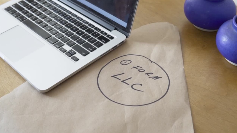 Laptop on a desk with a paper that says “Form LLC”