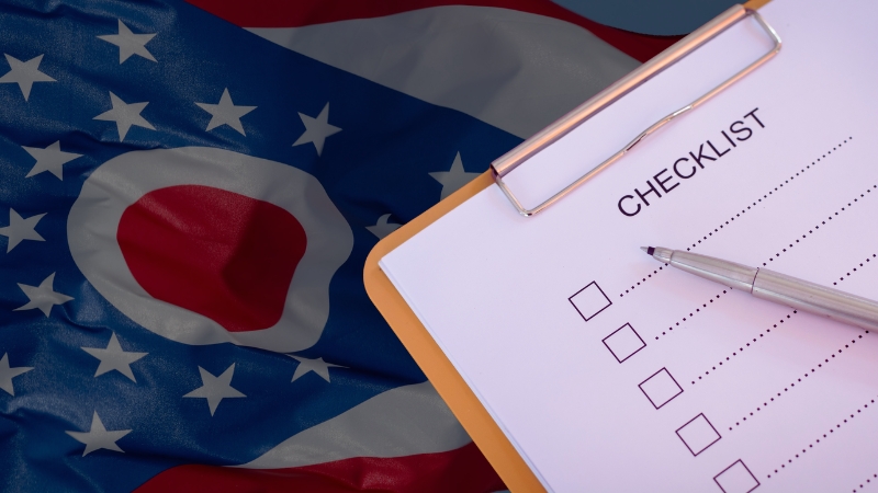 Checklist and pen on the Ohio flag for an Ohio business startup checklist