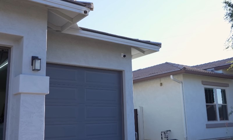 Photo of a hosue with the garage door open and safety cameras